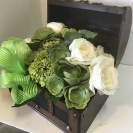 White roses and green succulents arranged in a small dark wooden chest