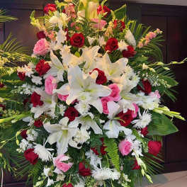 Large standing floral spray with white lilies, red and pink roses