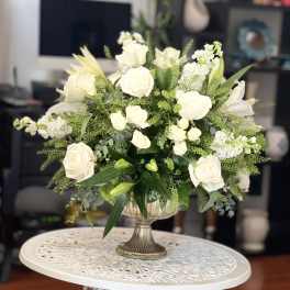 White rose arrangement in a silver pedestal vase