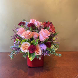 Pink and red rose bouquet in a red vase
