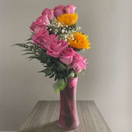 Pink roses and yellow daisies in a tall pink vase