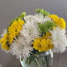 White and yellow chrysanthemum bouquet in a glass vase
