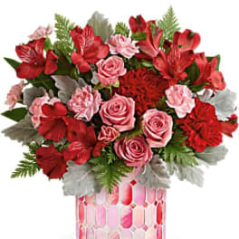 Bouquet of red and pink flowers in a pink mosaic vase