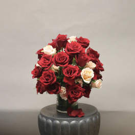 Bouquet of red and cream roses in a glass vase