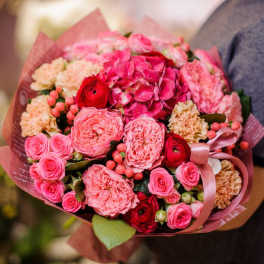 Pink bouquet with roses, hydrangea, and carnations wrapped in paper