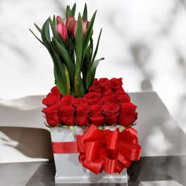 Red roses in a white box with pink tulips and a red bow