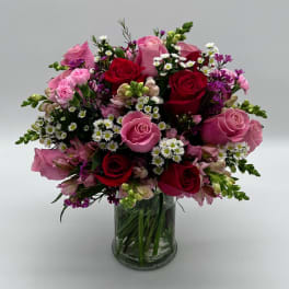 Bouquet of pink and red roses in a clear glass vase