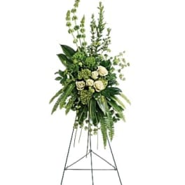 Tall white rose and greenery standing spray on an easel