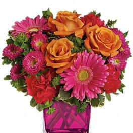 Bouquet of orange roses and pink daisies in a magenta glass vase