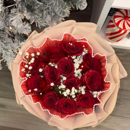 Bouquet of red roses with white baby's breath in pink wrapping