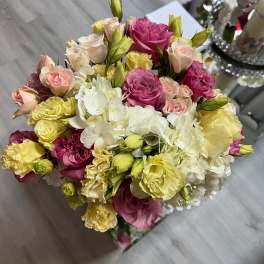 Bouquet of pink, cream, and yellow roses with white hydrangeas