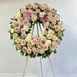 Heart-shaped wreath of pink and cream roses on an easel