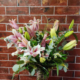 Bouquet of pink and white lilies in a glass vase