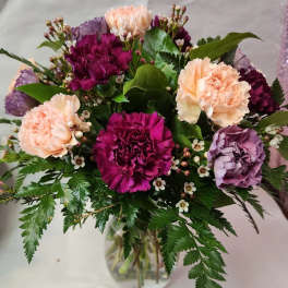 Bouquet of purple and peach carnations in a glass vase