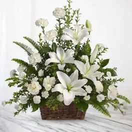 White lilies and carnations in a wicker basket