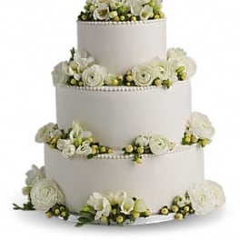 Four-tier white wedding cake with white flowers and yellow berries