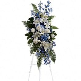 White and blue funeral spray on a standing easel