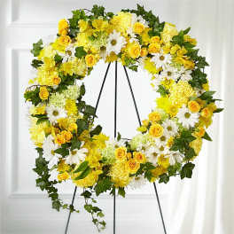 Yellow and white floral wreath on a black stand