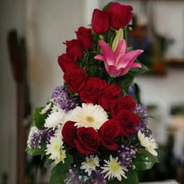 Tall bouquet of red roses, pink lily, and white daisies