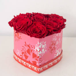 Heart-shaped pink box filled with tightly arranged red roses
