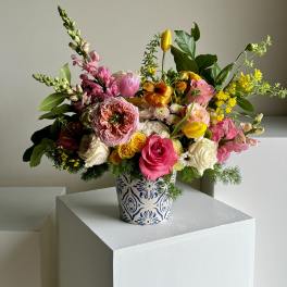 Mixed bouquet in a patterned ceramic vase with pink, yellow, and white flowers
