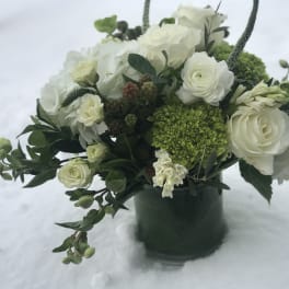 White and green floral arrangement in a dark vase