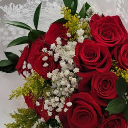 Bouquet of red roses with white baby's breath and greenery in decorative wrap