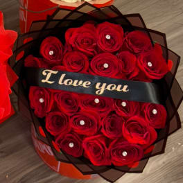 Red roses wrapped in black paper with a "I love you" ribbon