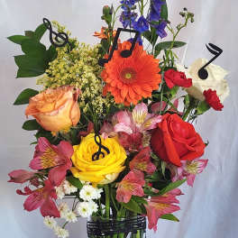 Mixed bouquet in a clear vase with colorful roses and alstroemeria