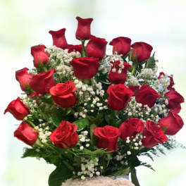 Red roses arranged in a teddy bear container with a heart ribbon