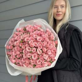 Large bouquet of pink roses wrapped in white paper