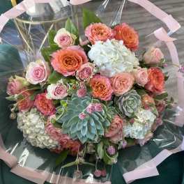 Bouquet of pink and orange roses with white hydrangeas and succulents