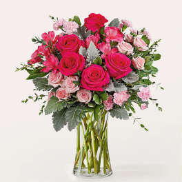 Pink roses and carnations in a clear glass vase
