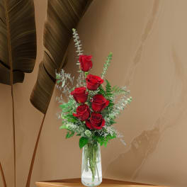 Red roses arranged in a clear glass vase