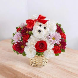 Flower arrangement shaped like a teddy bear with a red bow in a basket