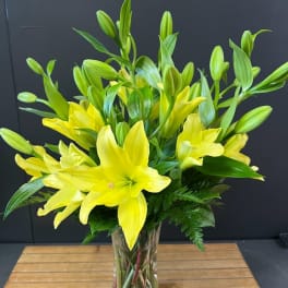 Yellow lilies in a clear glass vase