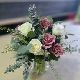 Bouquet of white and dusty pink roses with eucalyptus in a glass vase