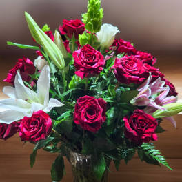 Bouquet of red roses and white lilies in a glass vase