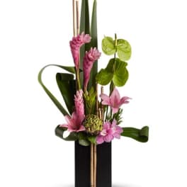 Tall tropical floral arrangement with pink blooms in a black vase