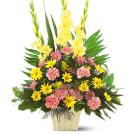Tall mixed flower arrangement in a gold vase with yellow and pink blooms