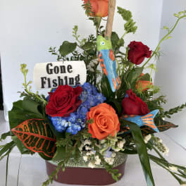 Mixed roses and blue hydrangeas in a decorative container with fishing-themed accents