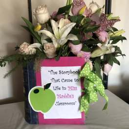 Bouquet of white lilies and pale roses in a decorated book-shaped container