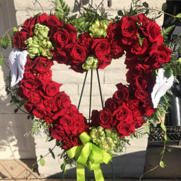 Heart-shaped red rose wreath with white angel wings and a lime ribbon
