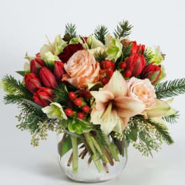 Bouquet of red and peach flowers in a clear glass vase