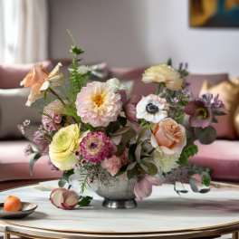 Pastel floral arrangement in a silver bowl on a table
