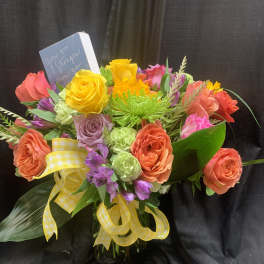 Colorful bouquet of roses and mixed flowers with a yellow ribbon in a vase