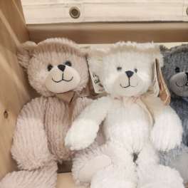 Three plush teddy bears in a wooden crate