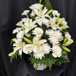 White lilies and chrysanthemums arranged in a white vase