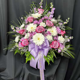 Pink and white floral spray with a lavender ribbon on black fabric