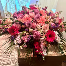 Large pink and purple floral arrangement with roses and gerbera daisies